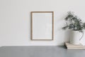 Christmas interior decor. Blank wooden picture frame mockup, white wall. Green pine tree branches in jug and old books Royalty Free Stock Photo