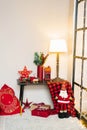 Christmas interior in the living room in red colors. On the table is a lamp, red mugs of cocoa, spruce branches in a vase. Next to Royalty Free Stock Photo