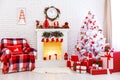 Christmas interior in red and white colors with tree and fireplace.