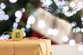 Christmas investing,bitcoin cryptocurrency gift on a background of lights and a christmas tree Royalty Free Stock Photo