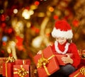 Christmas Kid Opening Present Gift Box, Happy Child in Santa Hat Royalty Free Stock Photo