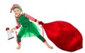 Christmas Kid pulling Santa Bag Full of Gifts. Funny Girl in Elf Costume with Red Huge Sack packed Xmas Presents. Christmas Child Royalty Free Stock Photo