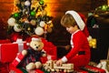 Christmas Kids concept. Happy kid is playing with Christmas toys on Christmas tree background. Kid is waiting for the Royalty Free Stock Photo