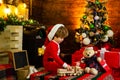 Christmas Kids concept. Happy kid is playing with Christmas toys on Christmas tree background. Kid is waiting for the