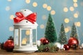 Christmas lantern with burning candle and festive ornaments on wooden table against blurred lights. Space for text Royalty Free Stock Photo