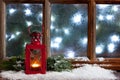Christmas lantern of fire and winter sill with frost window background Royalty Free Stock Photo