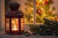 Christmas lantern in fornt of a window on a snowing night Royalty Free Stock Photo