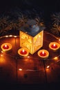 Christmas lantern with four candles on a wooden board Royalty Free Stock Photo