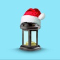 Christmas lantern in the hat of Santa Claus on a blue background. Isolated. New Year. Christmas background. Royalty Free Stock Photo