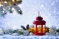 Christmas lantern in snow with fir tree branch and holiday decorations. Winter cozy scene Royalty Free Stock Photo