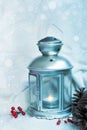 Christmas lantern with snowfall; Christmas background with pine cones and holly berries Royalty Free Stock Photo
