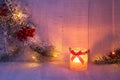 Christmas lantern and spruce branches with Christmas decorations on rustic wooden background at dusk . Toned image Royalty Free Stock Photo