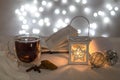 Christmas lantern, three balls, a book, tea and cookies on a bokeh background