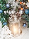 Christmas Lantern under Christmas tree with decoration, snow, blurred, sparking, glowing. Royalty Free Stock Photo