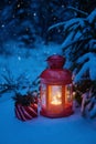 Christmas lantern under the tree with a gift in the woods. Chris Royalty Free Stock Photo