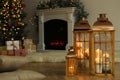 Christmas lanterns with burning candles in decorated living room. Space for text Royalty Free Stock Photo