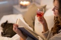 Happy young woman reading book in bed at home Royalty Free Stock Photo