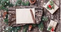 Christmas letter on wooden background with Christmas gifts, bark texture, pencil, Fir branches, pine cones, red decorations. Royalty Free Stock Photo