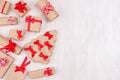 Christmas light background for your text, design - border of festive gift boxes with red bows and ribbons on soft white wood table Royalty Free Stock Photo