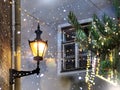 Christmas light in the city , tree branch and street lantern lamp with  festive garland on  medieval house wall and vintage window Royalty Free Stock Photo