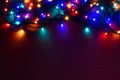 Christmas lights background with copy space. Glowing colorful Christmas lights on red grunge background. New Year. Royalty Free Stock Photo