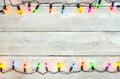 Christmas lights bulb frame decoration on white wood. Royalty Free Stock Photo