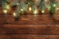 Christmas lights bulb and pine tree branches decoration on vintage wooden table. Merry Christmas and New Year holiday background. Royalty Free Stock Photo