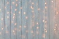 Christmas lights burning on a white wooden background. New Year back. Royalty Free Stock Photo