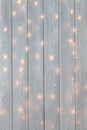 Christmas lights burning on a white wooden background. New Year back. Royalty Free Stock Photo