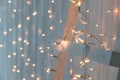 Christmas lights burning on a white wooden background. New Year back. Royalty Free Stock Photo