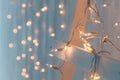 Christmas lights burning on a white wooden background. New Year back. Royalty Free Stock Photo