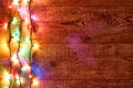 Christmas lights or Colorful garland on the left on wooden background. Bright and colorful New Year festive decorations Royalty Free Stock Photo