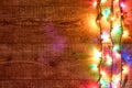 Christmas lights or Colorful garland on the right on wooden background. Bright and colorful New Year festive decorations Royalty Free Stock Photo