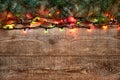 Christmas lights and fir tree branches on wooden background. New Year festive decorations with colorful glowing Royalty Free Stock Photo