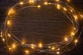 Christmas lights frame decoration on dark wood with copy space. Merry Christmas and New Year holiday background Royalty Free Stock Photo