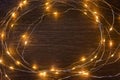 Christmas lights frame decoration on dark wood with copy space. Merry Christmas and New Year holiday background Royalty Free Stock Photo