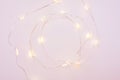 Christmas lights garland circular border over pink background with place for your text. Flat lay, copy space Royalty Free Stock Photo