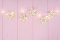 Christmas lights garland with stars border over pink background. Flat lay, copy space Royalty Free Stock Photo