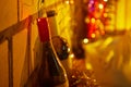 Christmas lights near bottles on background with white bricks Royalty Free Stock Photo