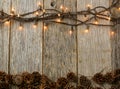 Christmas Lights and Pine cones on Rustic Wood