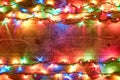 Christmas lights on a wooden background. Bright and colorful New Year festive decorations with glowing Christmas lights Royalty Free Stock Photo