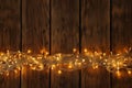 Christmas lights on wooden background, top view. Space for text Royalty Free Stock Photo