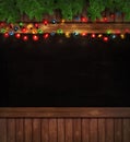 Christmas lights on wooden blackboard Royalty Free Stock Photo