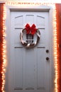 Christmas lights and wreath on front door at night