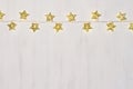 Christmas lights yellow stars burn on soft beige wooden background. Royalty Free Stock Photo