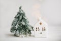 Christmas little house and tree with golden lights bokeh on white background. Festive modern decor. Happy holidays. Miniature cozy Royalty Free Stock Photo