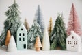 Christmas little houses and trees on white background. Festive modern decor. Happy holidays. Miniature cozy village, ceramic