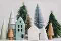 Christmas little houses and trees on white background. Holiday festive decor. Miniature village, ceramic houses, wooden christmas