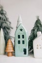 Christmas little houses and trees on white background. Holiday festive decor. Miniature village, ceramic houses, wooden christmas