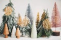 Christmas little trees and golden lights bokeh on white background. Winter magic forest, festive modern decor. Happy holidays. Royalty Free Stock Photo